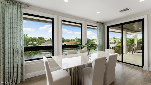 sunroom featuring a water view