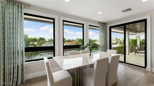 dining room with baseboards, wood finished floors, visible vents, and recessed lighting