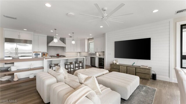 living area featuring wine cooler, visible vents, wood finished floors, and recessed lighting