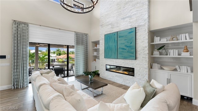 living room with hardwood / wood-style floors, built in shelves, and a high ceiling