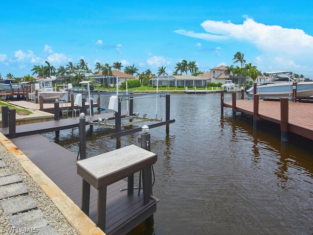 view of dock featuring a residential view, a water view, and boat lift