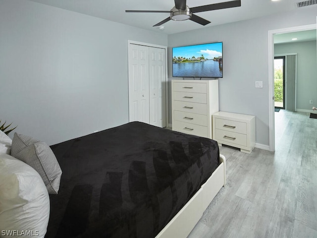 bedroom featuring ceiling fan, a closet, and light wood-type flooring