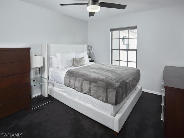 bedroom featuring a ceiling fan, baseboards, and dark carpet