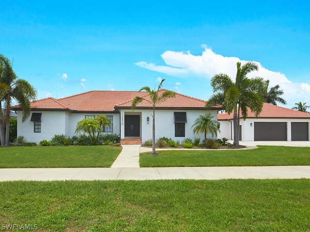 mediterranean / spanish house with a garage, stucco siding, a tiled roof, and a front yard