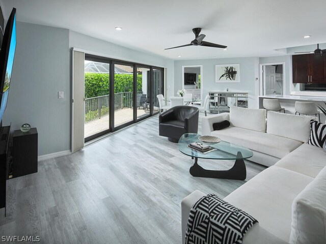 living room with ceiling fan and light hardwood / wood-style floors