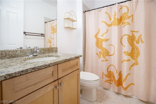 bathroom with toilet, vanity, and tile patterned floors