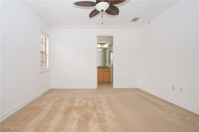 empty room featuring crown molding, ceiling fan, and light colored carpet