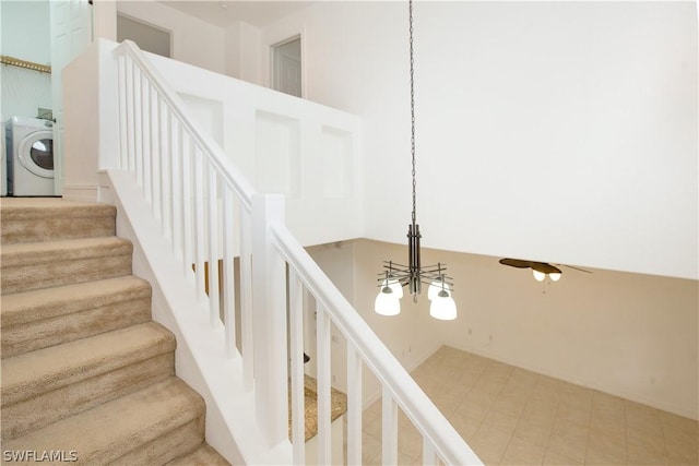 stairs featuring a chandelier and washer / dryer