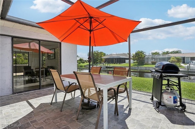 view of patio with a lanai, outdoor dining area, and area for grilling