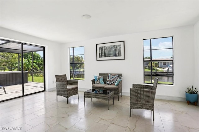 living area featuring marble finish floor and baseboards