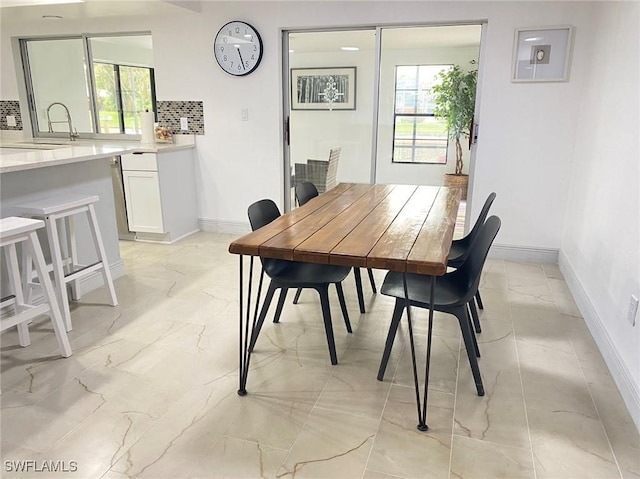 dining space with marble finish floor and baseboards