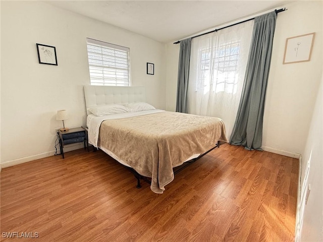 bedroom featuring multiple windows and light hardwood / wood-style floors