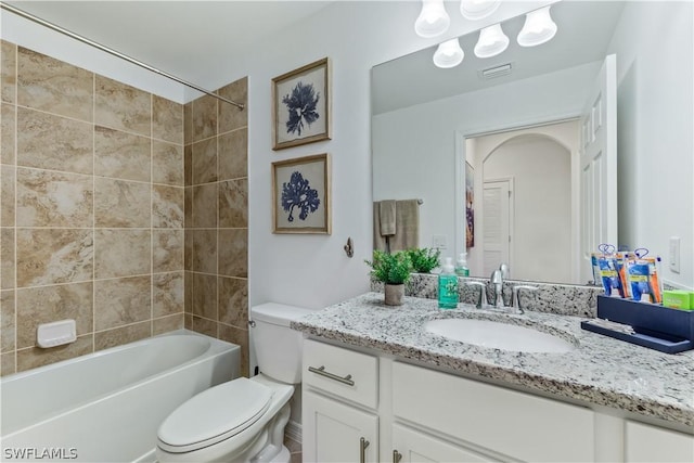 full bathroom featuring tiled shower / bath combo, vanity, and toilet