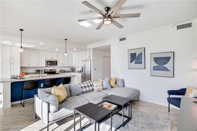 tiled living room with sink, crown molding, and ceiling fan