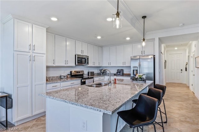 kitchen featuring appliances with stainless steel finishes, sink, hanging light fixtures, and white cabinets