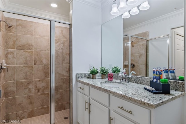 bathroom with a shower with shower door, vanity, and crown molding