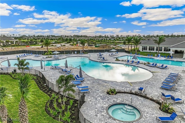 view of pool with a hot tub and a patio