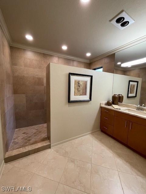 bathroom featuring a tile shower, tile patterned flooring, vanity, and ornamental molding