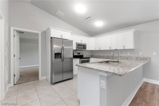 kitchen with white cabinets, appliances with stainless steel finishes, vaulted ceiling, and sink