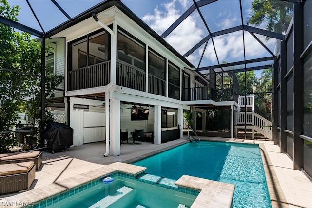 view of swimming pool with a patio, glass enclosure, and area for grilling