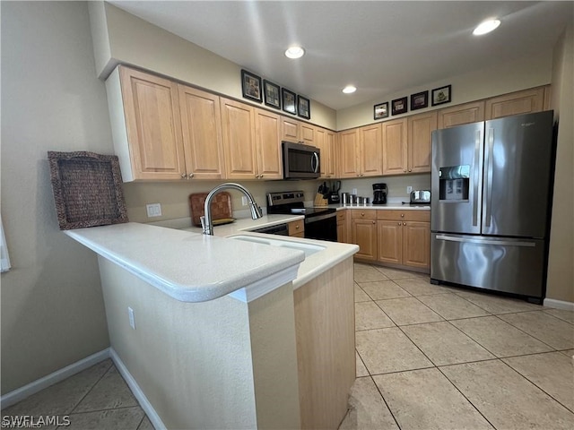 kitchen with appliances with stainless steel finishes, kitchen peninsula, light tile floors, and light brown cabinets