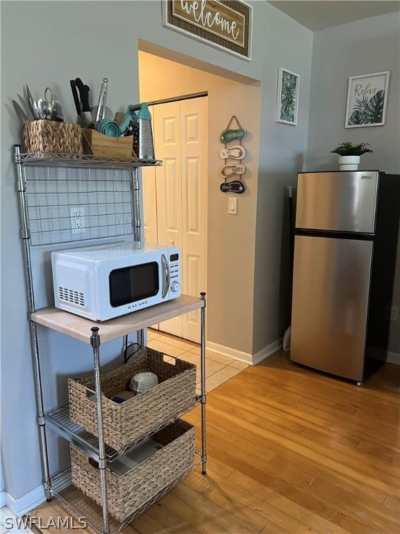 interior space featuring stainless steel refrigerator and light hardwood / wood-style flooring