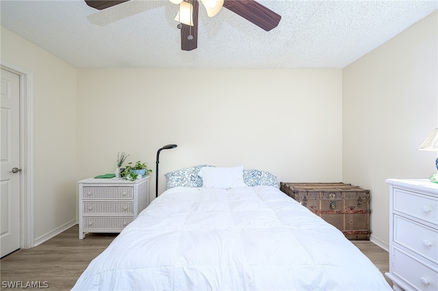 bedroom featuring a textured ceiling, ceiling fan, and hardwood / wood-style floors