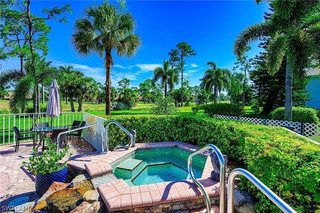 view of swimming pool featuring an in ground hot tub and a yard