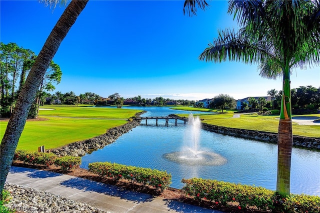 view of property's community with a lawn and a water view