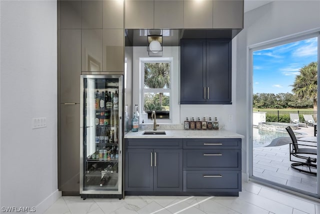 bar featuring gray cabinetry, plenty of natural light, sink, and beverage cooler