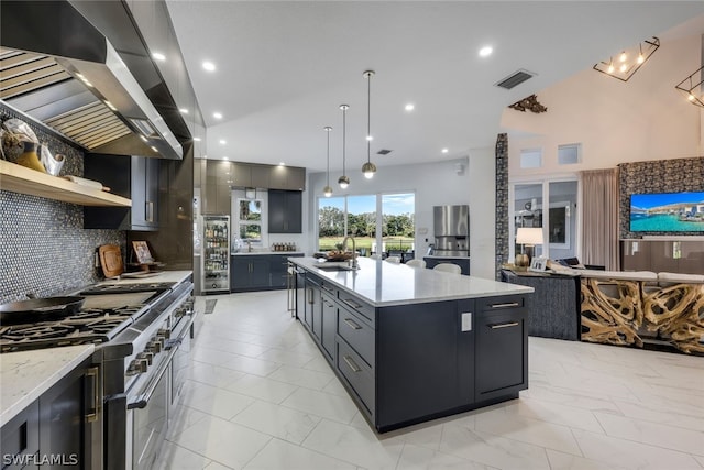 kitchen with pendant lighting, a spacious island, sink, wall chimney exhaust hood, and stainless steel appliances