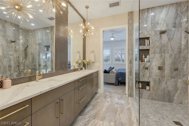 bathroom featuring tiled shower, vanity, and a notable chandelier