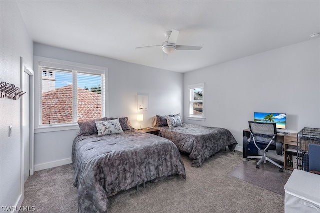 carpeted bedroom with multiple windows and ceiling fan