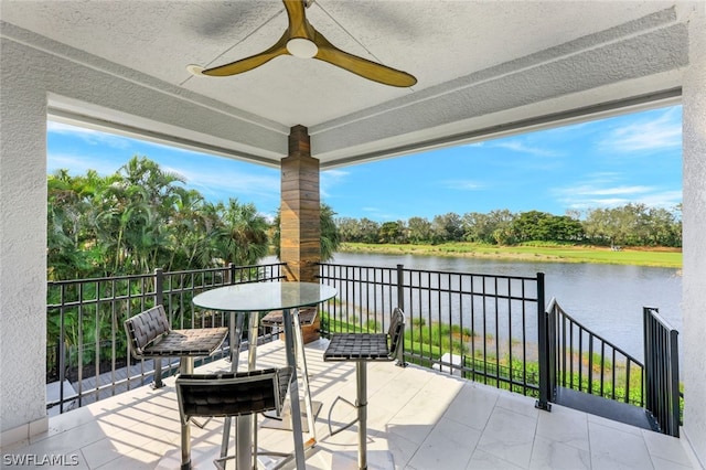 view of patio featuring ceiling fan and a water view