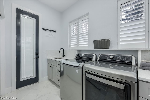 laundry room featuring cabinets, independent washer and dryer, and sink