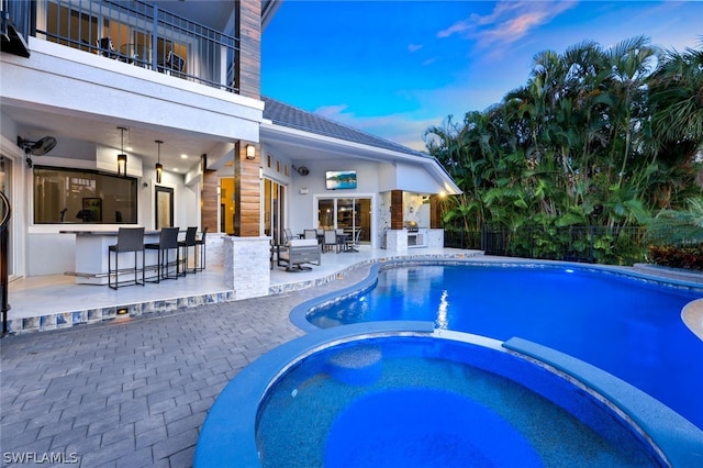 view of swimming pool with an in ground hot tub, a bar, and a patio