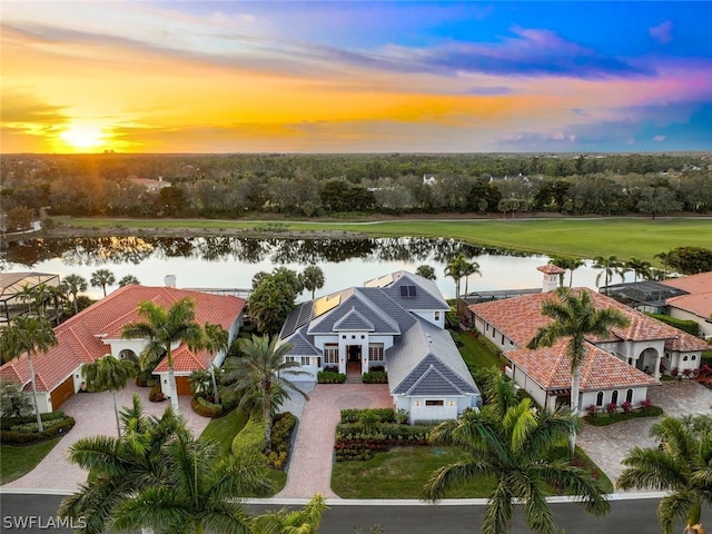 aerial view at dusk featuring a water view