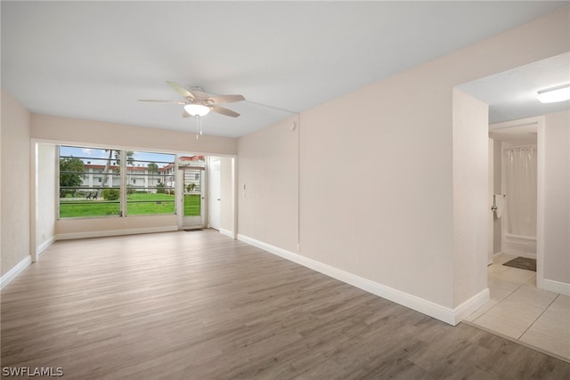 empty room with ceiling fan and light hardwood / wood-style floors