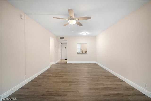 spare room with sink, dark wood-type flooring, and ceiling fan