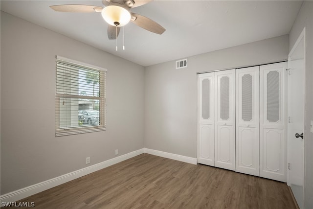 unfurnished bedroom with hardwood / wood-style flooring, a closet, and ceiling fan