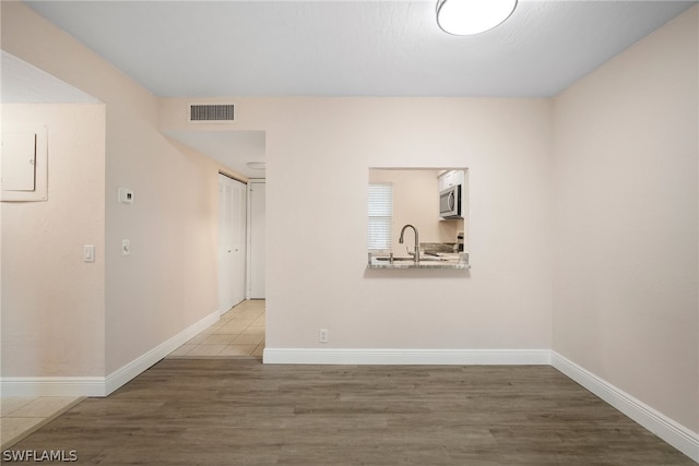 spare room with sink and hardwood / wood-style floors