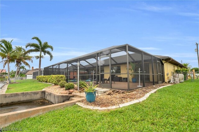 exterior space featuring glass enclosure, a patio area, and a yard