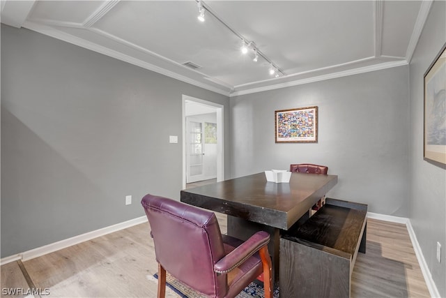 dining room with light hardwood / wood-style flooring, crown molding, track lighting, and lofted ceiling