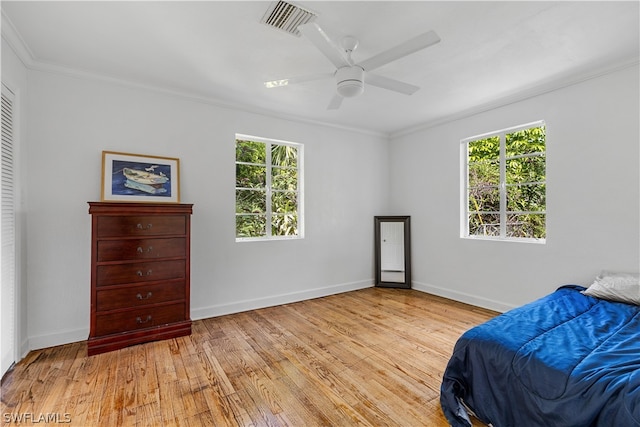 bedroom featuring ceiling fan, light wood-type flooring, and crown molding