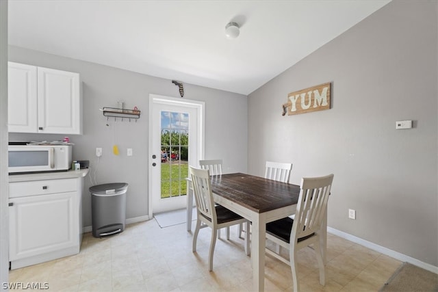 tiled dining space with lofted ceiling