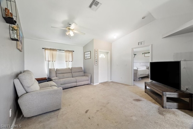 living room with ceiling fan, vaulted ceiling, and carpet flooring