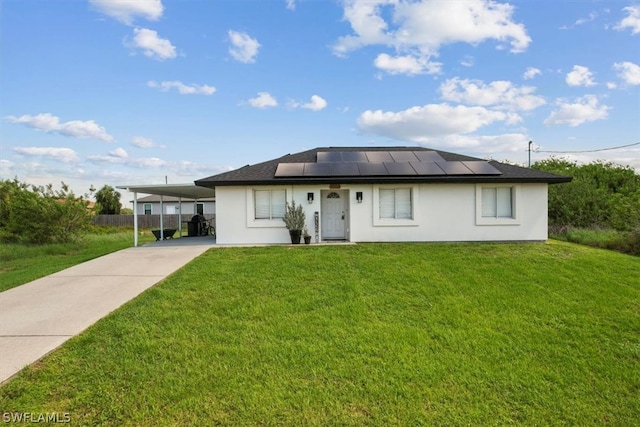 view of front of house with a front lawn, a carport, and solar panels