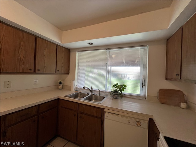 kitchen featuring range, white dishwasher, light tile patterned floors, and sink