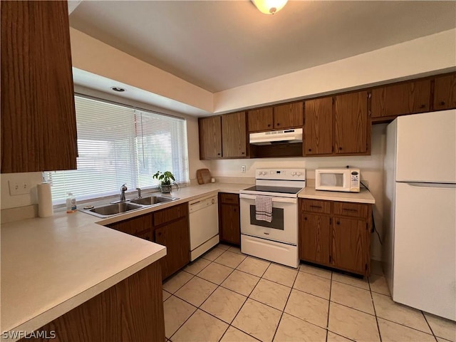 kitchen featuring white appliances, sink, and light tile patterned floors