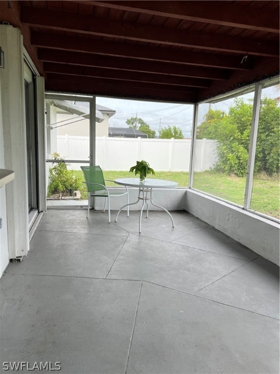 unfurnished sunroom featuring beam ceiling and wood ceiling